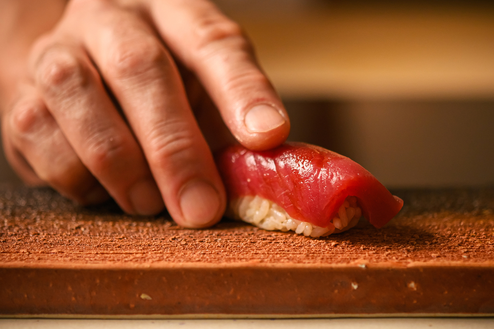 川崎の江戸前鮨 すし柳|職人がカウンターでマグロの握りを置く